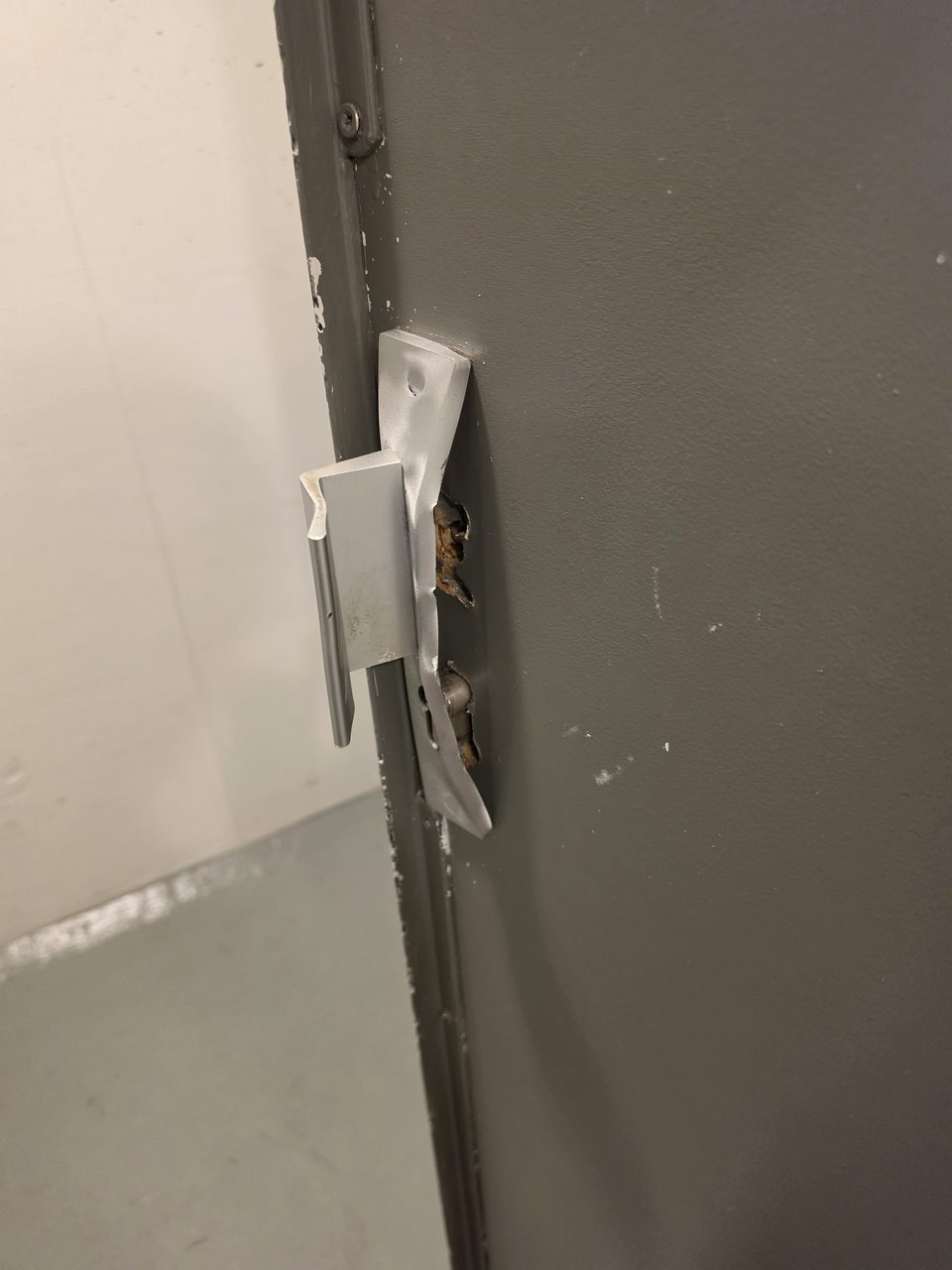 Serrure et têtière arrachées sur une porte métallique après une tentative d'effraction, dépannage serrurier à Lille